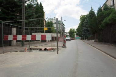 Siper yolda ve çitlerle çevrili. Tamir işleri. Şehirdeki iletişimin onarılması