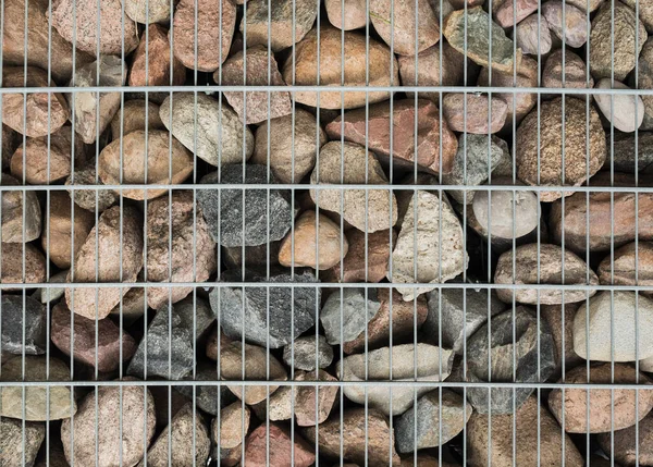 Taşların ve ağların arka planı. Doku taşı ve metal ağ