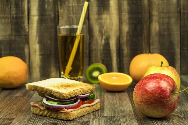 Kahvaltıda meyve suyu ve meyve suyu ile sandviç. Meyve suyu ve meyve suyu olan öğrenci için sağlıklı bir öğle yemeği. Teneffüste atıştırmalık.