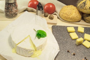 Dilimlenmiş Camembert peyniri. Yuvarlak peynir ve taze nane yaprakları.