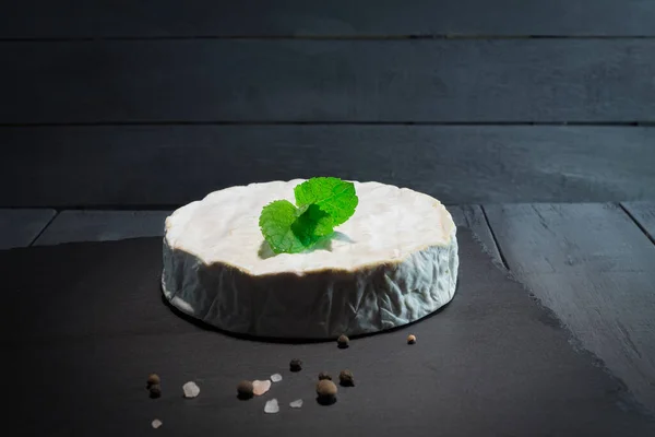 Photo of a round camembert cheese. Close-up of fresh and appetizing Camembert cheese