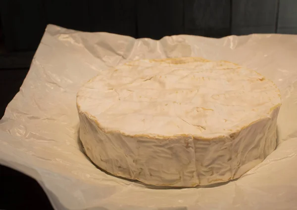 Photo of a round camembert cheese. Close-up of fresh and appetizing Camembert cheese