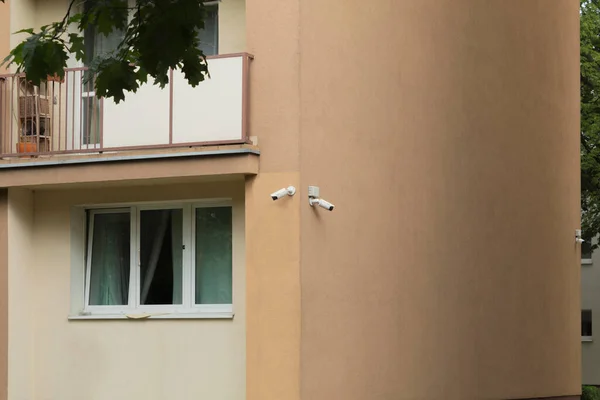 Security cameras on a residential building. Two outdoor security cameras on the corner of the house. Video tracking system