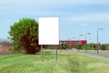 Şehir sokaklarının arka planında beyaz alan yazılı pankart ilanı. Şehir sokaklarının ve yeşil çimlerin arkasında