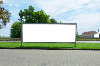 Şehir sokaklarının arka planında beyaz alan yazılı pankart ilanı. Şehir sokaklarının ve yeşil çimlerin arkasında