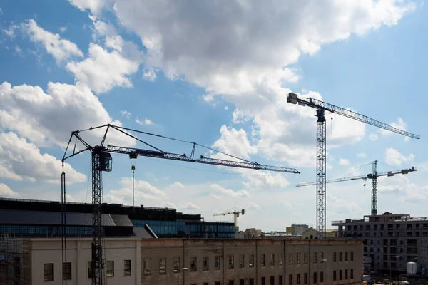 Gökyüzüne karşı dört kule vinci. İnşaat alanındaki inşaat malzemelerini kaldırmak için vinç