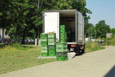 Minibüsten yiyecek kasalarını boşaltıyorum. Dükkan ve kafelere mal teslimatı