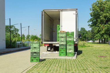 Minibüsten yiyecek kasalarını boşaltıyorum. Dükkan ve kafelere mal teslimatı