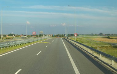 Hız limiti olan bir otoyolda yol tabelası. Arabadan yol manzarası. İşaretli ve yol işaretli yollar