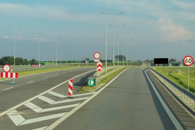 Hız limiti olan bir otoyolda yol tabelası. Arabadan yol manzarası. İşaretli ve yol işaretli yollar