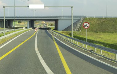 Hız limiti olan bir otoyolda yol tabelası. Arabadan yol manzarası. İşaretli ve yol işaretli yollar