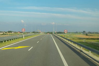 Hız limiti olan bir otoyolda yol tabelası. Arabadan yol manzarası. İşaretli ve yol işaretli yollar