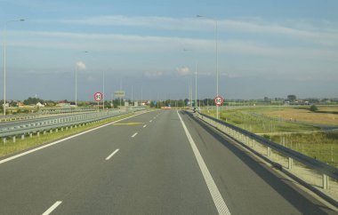 Hız limiti olan bir otoyolda yol tabelası. Arabadan yol manzarası. İşaretli ve yol işaretli yollar