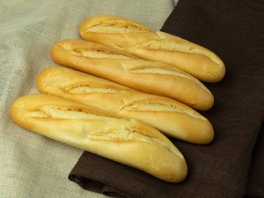 Mesajın arka planı olarak taze ve çıtır ekmekler. Mesaj, menü ya da reklamlar için yer. Kese kağıdında taze pişmiş ekmek