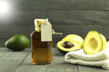 Etiketli bir şişe. Arka planda etiket olan bir şişedeki avokado yağı. Avokado ve yağ arkaplanı