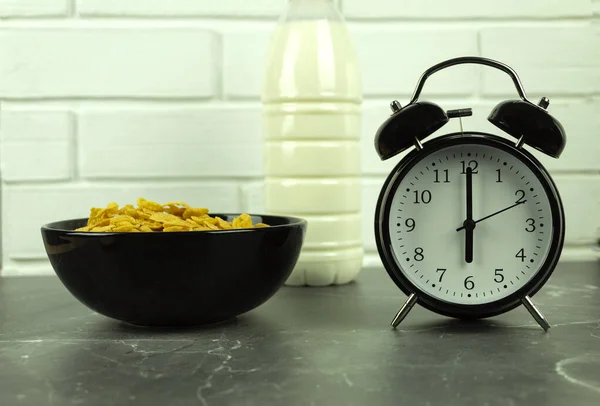 玉米片配牛奶当早餐 蜂蜜片和坚果与葡萄干和牛奶作为健康和健康的早餐 钟表显示早上六点 — 图库照片
