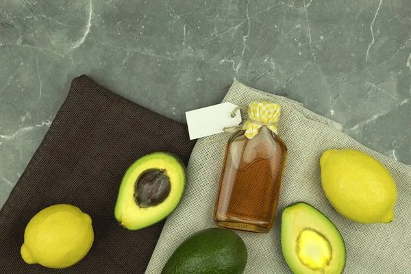 Avocado and oil in a glass bottle. Avocado fruit and oil. Background and place for text