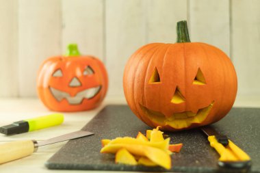 Cadılar Bayramı için balkabağını kendi ellerinle hazırlamak, cadılar bayramı kavramı. Cadılar Bayramı oymacılığı. Taze canavar kabağı. Tatil için balkabağı pişiriyorum.