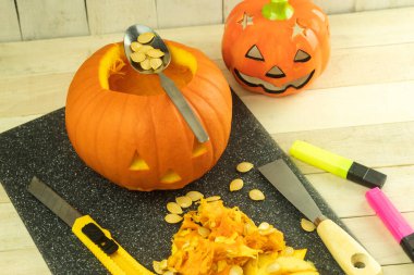 Cadılar Bayramı için balkabağını kendi ellerinle hazırlamak, cadılar bayramı kavramı. Cadılar Bayramı oymacılığı. Taze canavar kabağı. Tatil için balkabağı pişiriyorum.