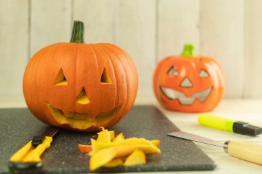 Cadılar Bayramı için balkabağını kendi ellerinle hazırlamak, cadılar bayramı kavramı. Cadılar Bayramı oymacılığı. Taze canavar kabağı. Tatil için balkabağı pişiriyorum.