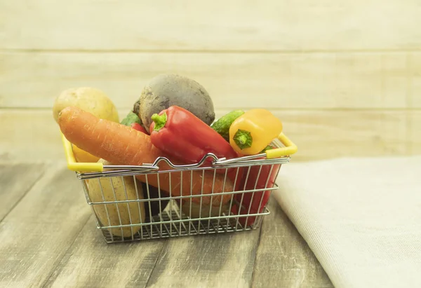 Fresh and healthy vegetables in the basket. Vegetables in an iron basket as a background with place for text. Fresh vegetables on the table and in the basket. Vegetables for vegetarians. Healthy petition