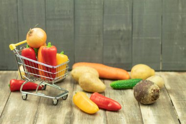 Arka plan olarak taze kırmızı biber ve sebzeler ve metin için yer. Sebzeli taze biberler masada ve sepetin içinde. Bir vejetaryene sebze.