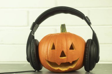 Cadılar bayramı için arka plan olarak taze balkabağı ve metin için yer. Fikir, müzik. Balkabağı müzik aşığı, kulaklıklı balkabağı.