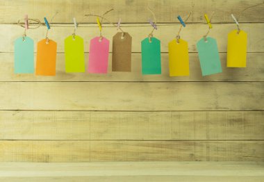 Arkaplan olarak farklı renklerde etiketler. Arkaplan olarak halat etiketleri. Etiketler çok renkli mandalların üzerinde asılı duruyor.