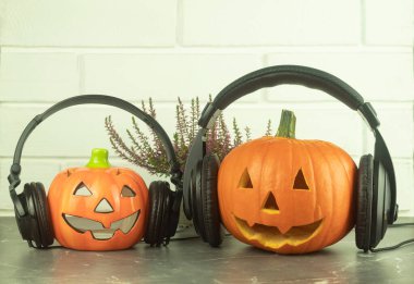 Mutfak masasında kulaklık olan bir balkabağı. Metin için yeri olan müzikal bir arkaplan fikri