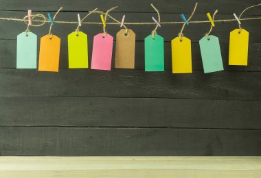 Arka plan ve farklı renklerde dokuz etiket. Metin için etiket ve yazıtlar. Etiketler çok renkli mandallarla bir ipe asılmış..