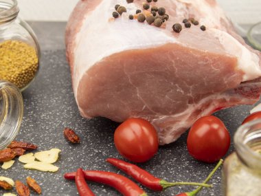 Misket tahtasında çiğ domuz eti, baharatlar ve sebzelerle.