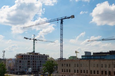 Varşova, Polonya - 23 Temmuz 2020: farklı yüksekliklerde bulunan beş inşaat kulesi vinci. Gökyüzüne karşı inşaat kulesi vinçleri