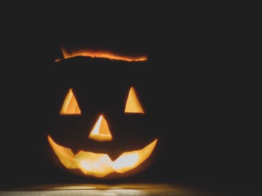 İçinde yanan bir mum olan balkabağı feneri. Karanlıkta balkabağı feneri. Karanlık arka plan ve metin için yer ile Cadılar Bayramı tatil arka planı