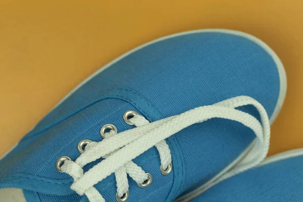 蓝色运动鞋上的白色鞋带 黄色背景 蓝色运动鞋为背景 文字位置 — 图库照片