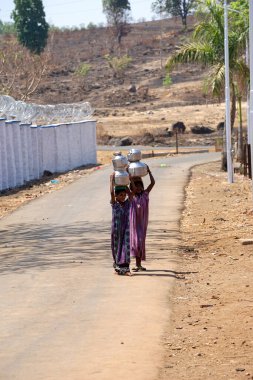 Maharashtra, Hindistan / 6 Mayıs 2016: Çocuklar, Dhakne köyü, Shahapur Taluka, Thane İlçesi 'ndeki neredeyse kuru bir kuyudan su getiriyor