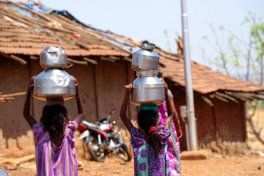 Maharashtra, Hindistan / 6 Mayıs 2016: Çocuklar, Dhakne köyü, Shahapur Taluka, Thane İlçesi 'ndeki neredeyse kuru bir kuyudan su getiriyor