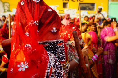 Nandgaon, Hindistan / 18 Mart 2016: Kadınlar Lath mar Holi, Lathmar Holi 'yi Nandgaon, Mathura, Uttar Pradesh' te kutlamaya hazırlanırken sopalarla ayakta duruyorlar.