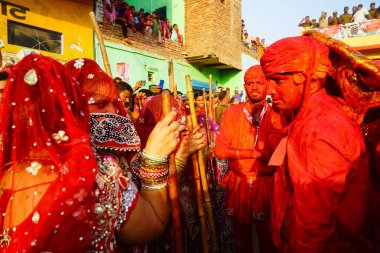 Nandgaon, Hindistan / 18 Mart 2016: Erkekler Nandgaon, Mathura, Uttar Pradesh 'te Lath mar Holi, Lathmar Holi kutlamaları kapsamında kadınlara sataşıyor.
