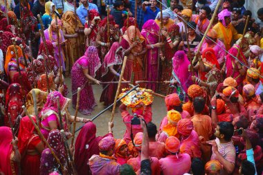 Nandgaon, Hindistan / 18 Mart 2016: Kadınlar Nandgaon, Mathura, Uttar Prades 'te düzenlenen Lathmar Holi kutlamaları kapsamında erkekleri bambu çubuklarla dövdü