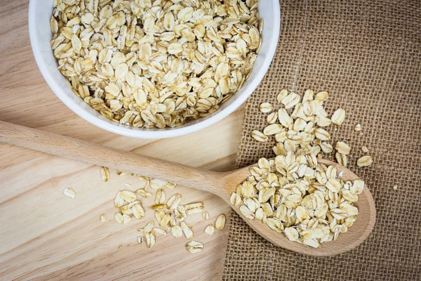 Cuenco y cuchara con avena cruda — Foto de Stock