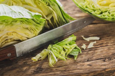 Tahta kesme tahtasının üzerinde bıçakla doğranmış lahana kompozisyonu