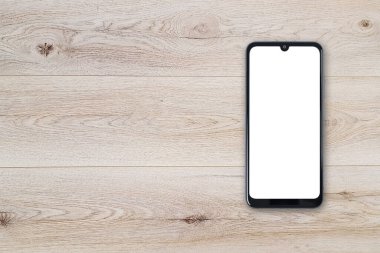 Ahşap bir tablo üzerinde boş beyaz ekranı olan yeni bir siyah çerçevesiz akıllı telefon modelinin üst görünümü (boşluğu kopyala).