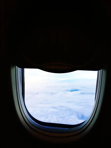 在黑暗的机舱里 飞机的窗户是半开着的 天空在云彩之上 — 图库照片