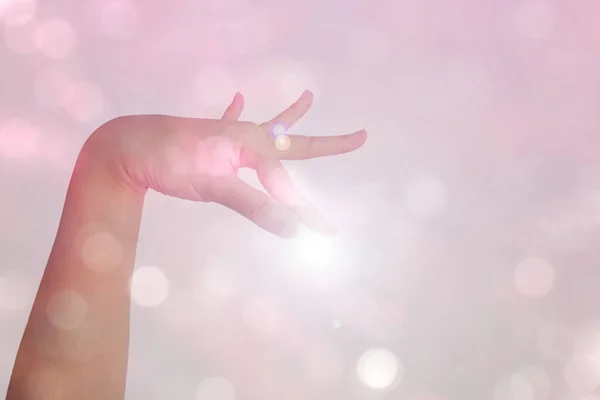 hand of Asian woman show hand is Pleat gesture in Thai dance with white sunlight isolated on bokeh background