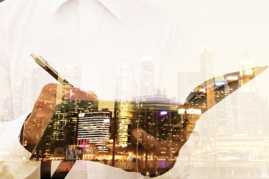 İş adamı, yatırım için bilgi toplamak amacıyla çalışırken ve araştırırken defterine notlar yazıyor.