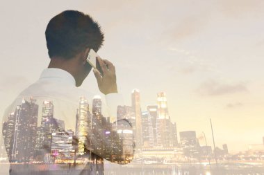 Şehirdeki yatırımlara hazırlanmak için iş adamı telefonda konuşuyor.