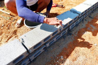 Tuğlacı tuğlalarla ev kirişini inşa ediyor..