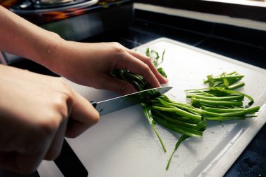Kadının eli kesme tahtasıyla sabah zaferini kesiyor mutfakta bıçakla..