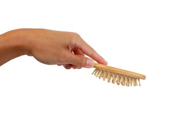 Asyalı adamın eli ahşap tarağı tutuyor. Özel efektlerle ahşaptan yapılmış bu iğne, beyaz arka planı tararken kafaya masaj yapabilir.