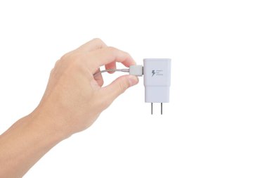 Asyalı adamın eli, beyaz arka planda akıllı telefon için adaptör şarj cihazını bekletiyor.